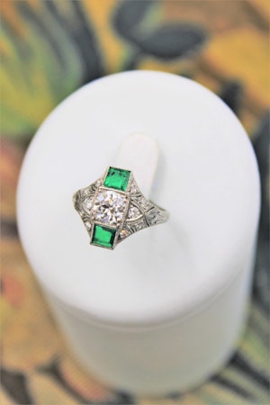 Downstairs at Grays, an extraordinarily stylish, Antique Platinum "Art Deco" 1.00 Carat Diamond & two "Square Cut" Emerald Ring, Circa 1935