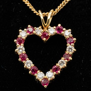 Ruby and diamond heart shaped gold pendant on gold chain