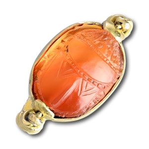 Gold ring with an Etruscan carnelian scarab of a figure carrying an amphora.
