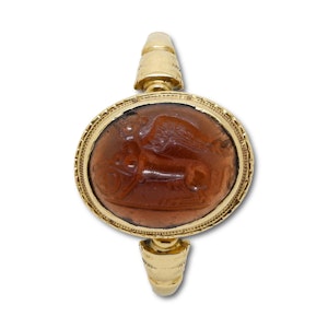 Gold ring with a cabochon garnet intaglio of a sphinx. Roman, 1st - 2nd century.