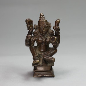 Indian miniature bronze of a seated four-armed figure, mid-19th century