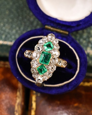 Downstairs at Grays: A fine 18 ct. Yellow Gold, Navette shaped ring set with three Octagonal Step Cut Natural Emeralds & numerous Diamonds, with Diamond set shoulders. English. Circa 1870.