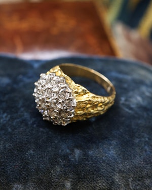 Downstairs at Grays: A Very Fine 18 Carat Yellow & White Gold (stamped), Diamond Cluster Ring, with an Abstract Bark Design to each Shoulder. Circa 1970.