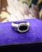Downstairs at Grays: An 18ct (marked) Brushed White Gold Plaque Ring, with Oval Black Onyx, surrounded by a gallery of Single Cut Diamonds. Circa 1970 - image 2