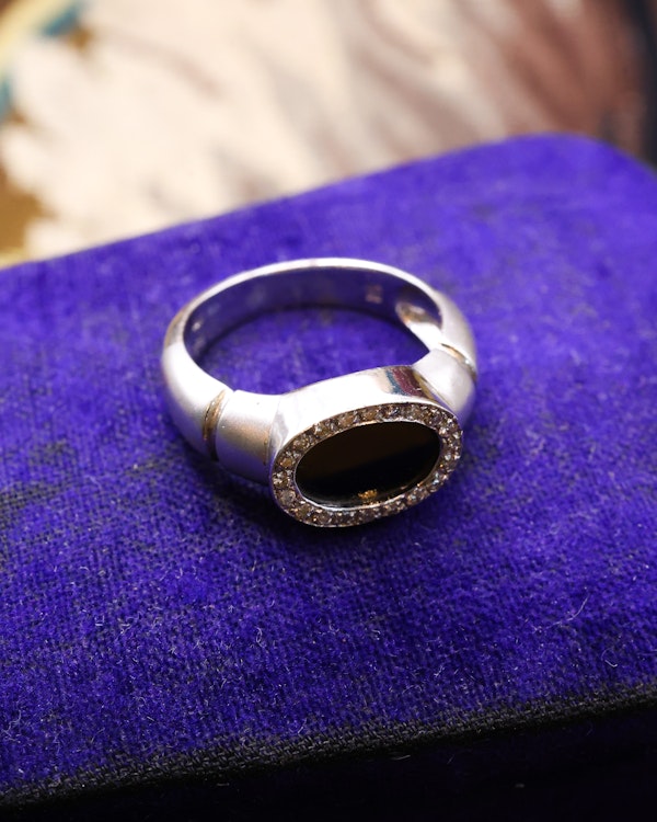 Downstairs at Grays: An 18ct (marked) Brushed White Gold Plaque Ring, with Oval Black Onyx, surrounded by a gallery of Single Cut Diamonds. Circa 1970 - image 4