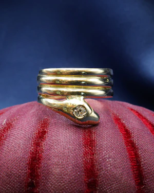 Downstairs at Grays: very fine 18 Carat Yellow Gold (tested),Triple Coil Snake Ring, with an old cut Diamond of approximately 0.27 Carats, Circa 1910