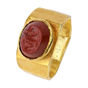 Ancient angular gold ring set with a jasper intaglio of an allegorical scene.